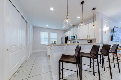 a kitchen with a bar with stools at ECR7609 - 6B Enchanted Vacation Home @Encore in Orlando