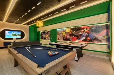 a billiard room with a pool table and a tv at Luxurious 15-Bedroom Villa With Pool & Games Room in Kissimmee