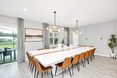 a dining room with a large white table and chairs at Luxurious 15-Bedroom Villa With Pool & Games Room in Kissimmee