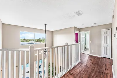 a staircase in a home with a white railing at Luxury 8-Bed Villa Near Disney With Pool & More in Kissimmee