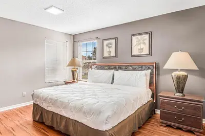 a bedroom with a bed and two lamps and a window at Luxury 8-Bed Villa Near Disney With Pool & More in Kissimmee