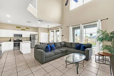 a living room with a couch and a glass table at Luxury 8-Bed Villa Near Disney With Pool & More in Kissimmee