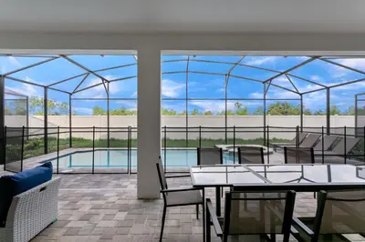 a glass house with a table and chairs and a pool at Ev1810 - Solara Galaxy Villa in Orlando
