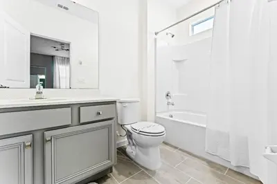 a white bathroom with a toilet and a sink and a tub at Ev2440 - Orlando Luxe Retreat in Kissimmee
