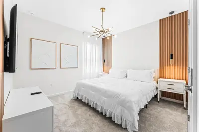 a white bedroom with a bed and a television at Ev2440 - Orlando Luxe Retreat in Kissimmee