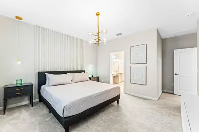 a bedroom with a bed and a chandelier at Ev2440 - Orlando Luxe Retreat in Kissimmee