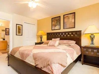 a bedroom with a bed with two night stands and two lamps at Ev2753 - Golden Horizon Villa in Kissimmee