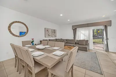 a dining table and chairs in a living room at Ev30360 - Encantada Villa in Kissimmee