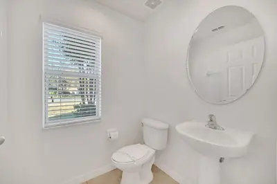 a white bathroom with a toilet and a mirror at Ev30360 - Encantada Villa in Kissimmee