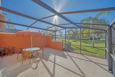 a patio with a table with chairs and an umbrella at Ev30360 - Encantada Villa in Kissimmee