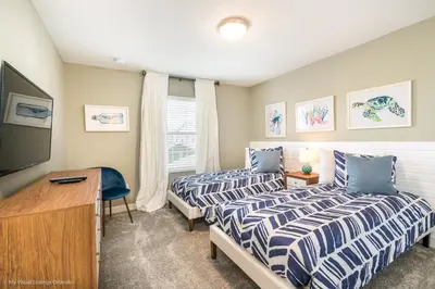 a bedroom with two beds and a desk and a television at Ev4958 - Sunset Cove Villa in Kissimmee