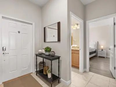 a hallway with a white door and a table with a mirror at Ev4891 - Harmony Haven Retreat in Kissimmee