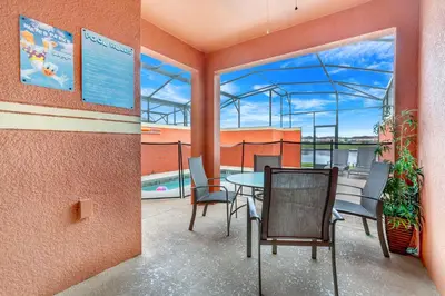 a patio with a table and chairs on a balcony at Ev8944 - Paradise Palms Escape in Kissimmee