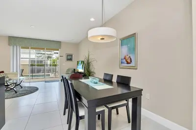 a dining room with a black table and chairs at Ev1445 - The Palm Retreat in Orlando