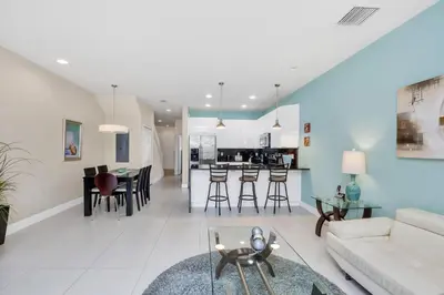 a living room and kitchen with a couch and a table at Ev1445 - The Palm Retreat in Orlando