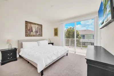 a white bedroom with a bed and a large window at Ev1447 - The Retreat Villa in Orlando