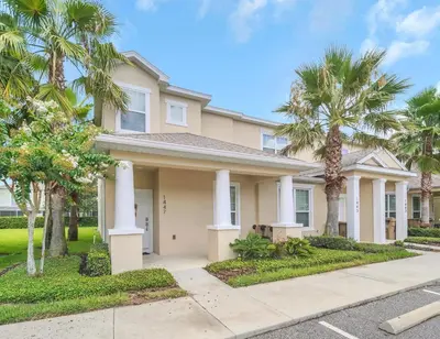 a house with palm trees in front of it at Ev1447 - The Retreat Villa in Orlando
