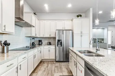 a kitchen with white cabinets and a stainless steel refrigerator at Ev1472 - Reunion Getaway in Orlando