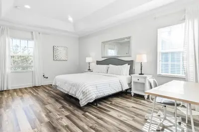 a white bedroom with a bed and a table at Ev1472 - Reunion Getaway in Orlando