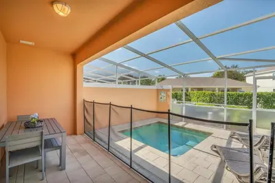 a balcony with a swimming pool and a table at Ev1511 - The Serenity Villa in Orlando