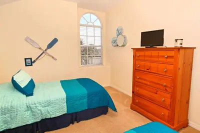 a bedroom with a bed and a dresser with a television at Ev1915 - Sunset Glen Villa in Orlando