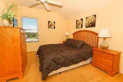 a bedroom with a bed and a dresser and a window at Ev1915 - Sunset Glen Villa in Orlando