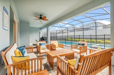 a balcony with chairs and tables and a pool at Ev2010 - Windsor Star Retreat in Kissimmee