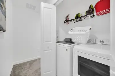 a white laundry room with a washer and dryer at Ev2444 - Palm Breeze Escape in Kissimmee