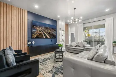 a living room with two white couches and a blue wall at 2558Shanti in Kissimmee