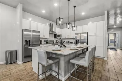 a large kitchen with a large island with bar chairs at 2558Shanti in Kissimmee