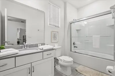 a white bathroom with a toilet and a glass shower at 2558Shanti in Kissimmee