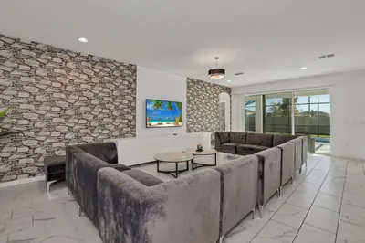 a living room with couches and a stone wall at Ev2613 - Grand Horizon Manor in Kissimmee