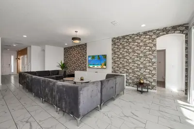a living room with a couch and a stone wall at Ev2613 - Grand Horizon Manor in Kissimmee