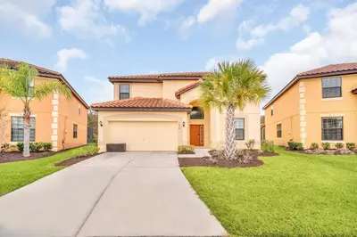 a house with a garage and palm trees at Ev2628 - Veranda Palms Hideaway in Kissimmee