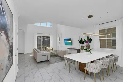 a dining room and living room with a table and chairs at Ev2669 - Sunshine Escape Villa in Kissimmee
