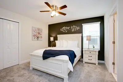 a bedroom with a white bed and a ceiling fan at Ev2709 - Enchanted Retreat Villa in Kissimmee