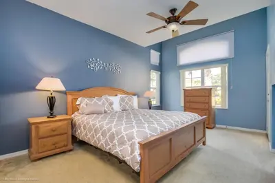 a bedroom with blue walls and a bed and a ceiling fan at Ev2739 - Emerald Serenity Villa in Kissimmee