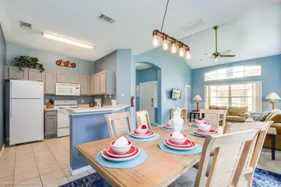 a kitchen and dining room with a table and chairs at Ev2739 - Emerald Serenity Villa in Kissimmee