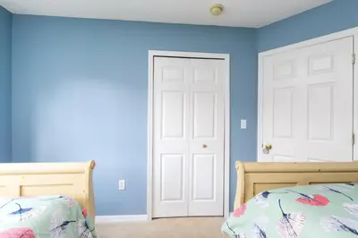 a bedroom with blue walls and a white door at Ev2739 - Emerald Serenity Villa in Kissimmee