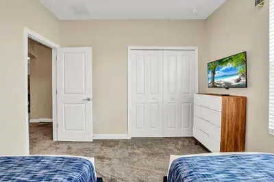 a bedroom with two beds and a dresser at Ev2755Book - Golden Horizon Villa in Kissimmee