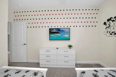 a bedroom with a white dresser and red stars on the wall at Ev2775 - Majestic Escape Villa in Kissimmee