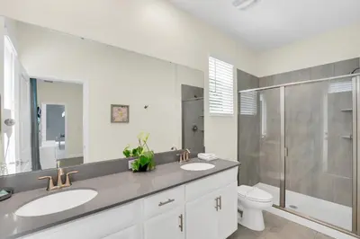 a bathroom with two sinks and a shower and a toilet at Ev2775 - Majestic Escape Villa in Kissimmee