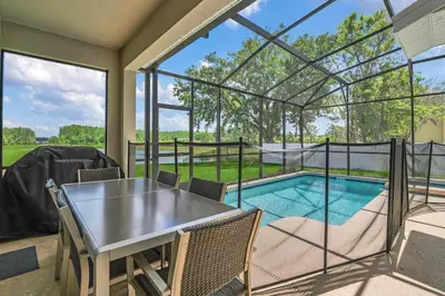 a screened in porch with a table and a swimming pool at Ev2775 - Majestic Escape Villa in Kissimmee