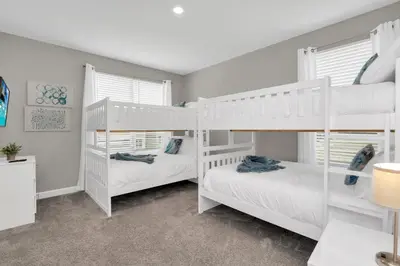 two white bunk beds in a white room with windows at Ev2775 - Majestic Escape Villa in Kissimmee