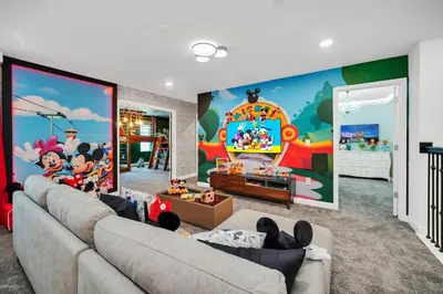 a living room with a large mural of a game room at Ev2900 - Sunset Cove Retreat in Kissimmee
