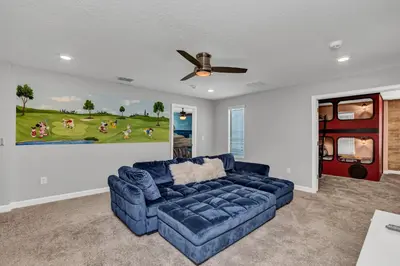 a living room with a blue couch and a painting on the wall at Ev2909 - Storey Lake Haven in Kissimmee