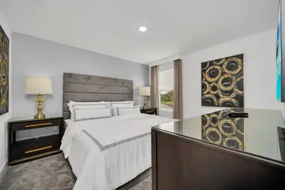 a white bedroom with a bed and a window at Ev2989 - Serenity Palms Villa in Kissimmee