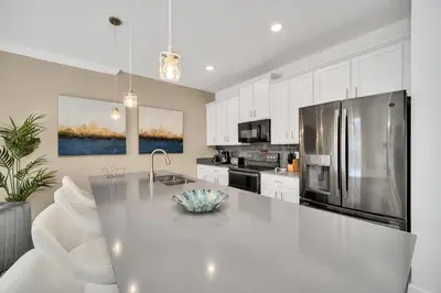 a kitchen with a stainless steel refrigerator and white cabinets at Ev3007 - Lakeside Escape Villa in Kissimmee