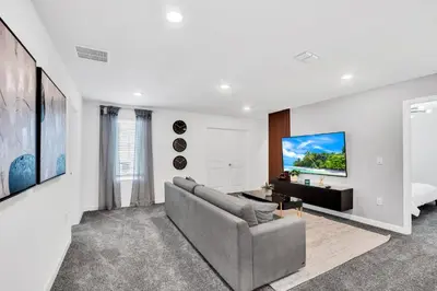a living room with a couch and a tv on a wall at Ev3009 - Grand View Retreat in Kissimmee