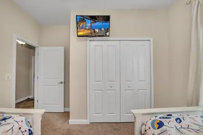 a bedroom with two beds and a tv on the wall at Ev3097 - Lakeside Serenity Villa in Kissimmee